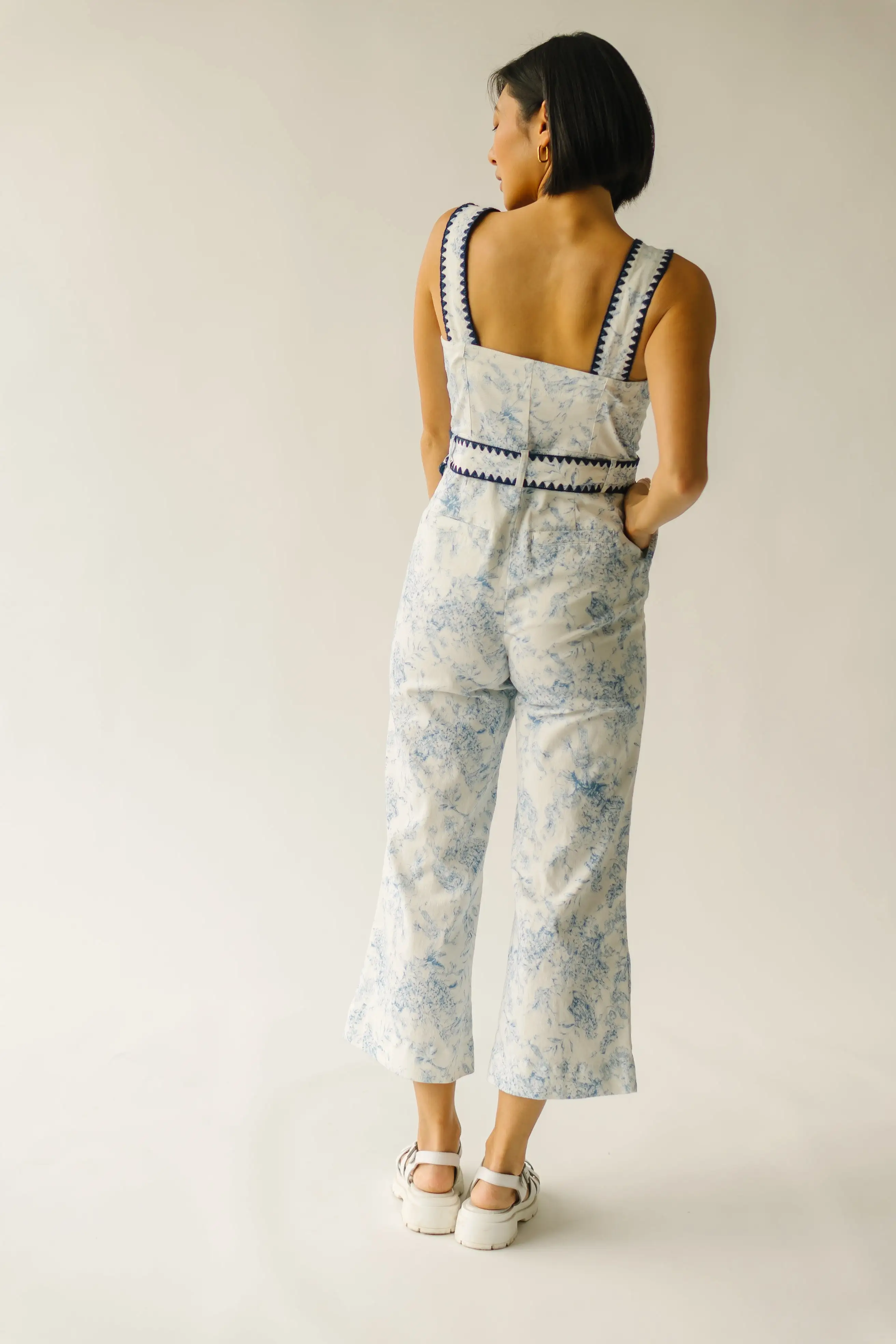 The Almada Belted Floral Jumpsuit in Ivory + Blue